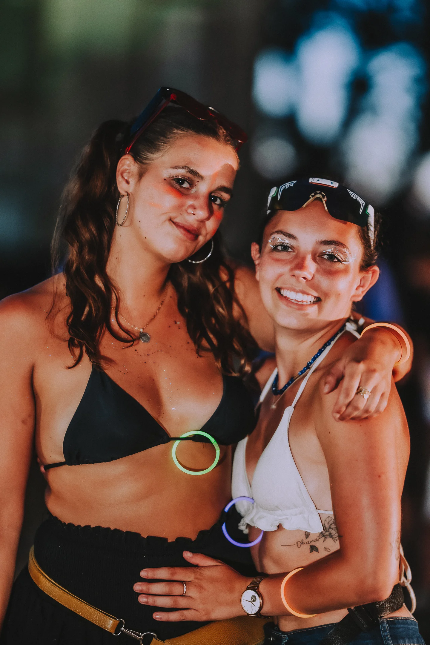 Deux festivalieres avec du maquillage à paillettes posant ensemble et souriant au M2A Festival